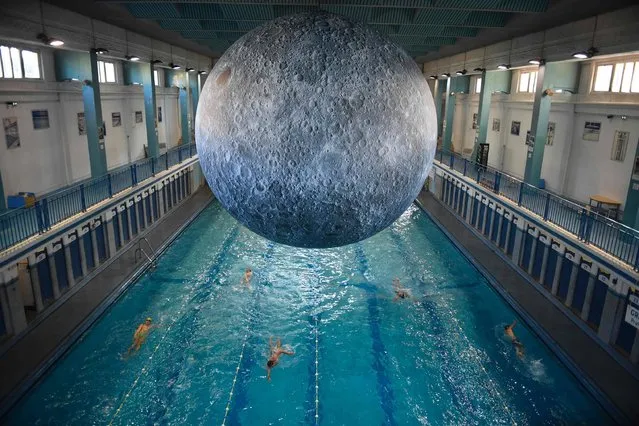 People swim under an artwork “Museum of the Moon” by British artist Luke Jerram at the Saint-Georges swimming pool in Rennes, western France on June 12, 2017. (Photo by Damien Meyer/AFP Photo)
