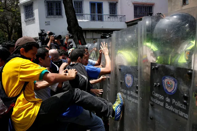 Demonstrators clash with riot police officers during a protest called by university students against Venezuela's government in Caracas, Venezuela, June 9, 2016. (Photo by Carlos Garcia Rawlins/Reuters)
