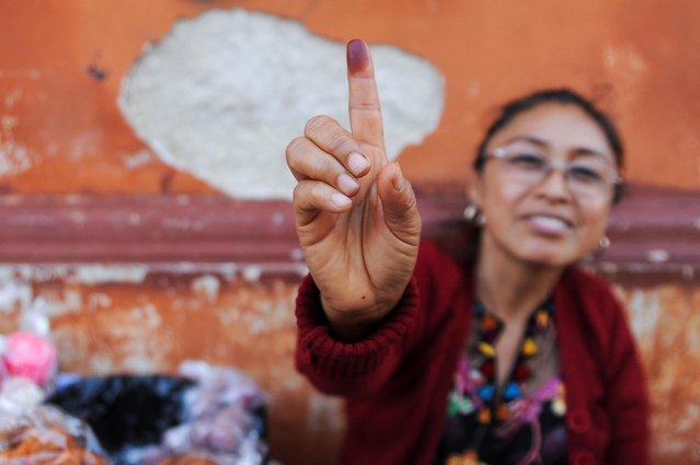 A woman shows her ink-stained finger during the first round of Guatemala's presidential election in Guatemala City, Guatemala on June 25, 2023. (Photo by Cristina Chiquin/Reuters)