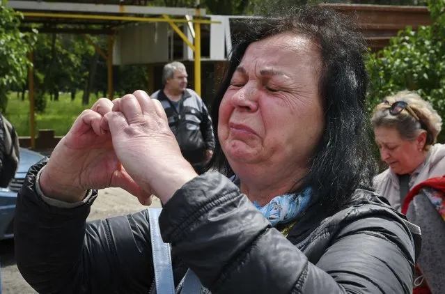 A woman reacts during an evacuation of civilians in Soledar, Donetsk region, Ukraine, Tuesday, May 24, 2022. (Photo by Andriy Andriyenko/AP Photo)