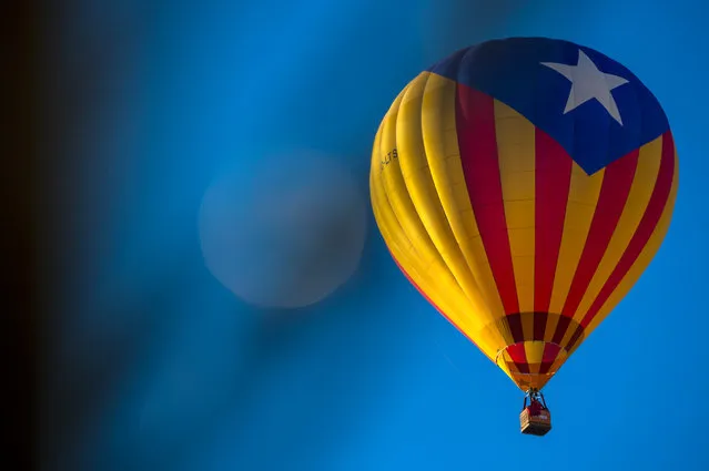A hot air balloon with a Catalan pro-independence flag flies over Igualada during an early flight as part of the European Balloon Festival on July 10, 2014 in Igualada, Spain. The early morning flight of over 30 balloons was shorter than expected due to windy weather. This flight is organised as a curtain raiser for the four-day European Balloon Festival. Now is the 18th year of the most important hot air Balloon event in Spain and one of the biggest in Europe. (Photo by David Ramos/Getty Images)