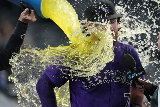 Colorado Rockies' Charlie Blackmon, left, douses Brendan Rodgers after the latter's two-run home run off Miami Marlins relief pitcher Cole Sulser during the 10th inning of the second game of a baseball doubleheader Wednesday, June 1, 2022, in Denver. (Photo by David Zalubowski/AP Photo)