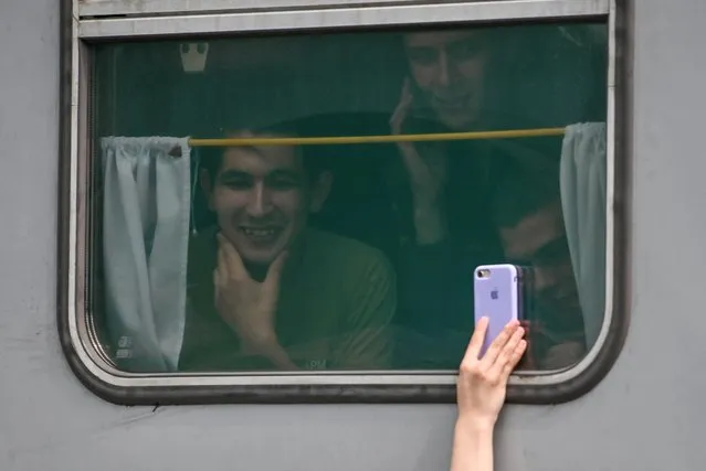 Conscripts, wearing military uniforms, look on in a train carriage at a local railway station during their departure for the garrisons, in Omsk, Russia on June 17, 2022. (Photo by Alexey Malgavko/Reuters)