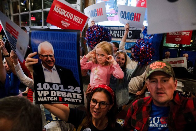 Margaret Jagdfeld, 4, covers her ears as alumni of Mankato West High School, where vice presidential candidate Tim Walz formerly taught, cheer for Walz at a debate watch party in St. Paul, Minnesota, on Tuesday, October 1, 2024. (Photo by Erica Dischino/Reuters)