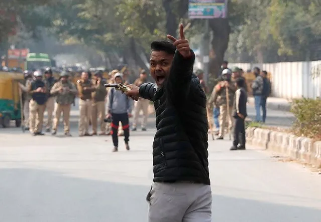 An unidentified man reacts as he brandishes a gun during a protest against a new citizenship law outside the Jamia Millia Islamia university in New Delhi, India, January 30, 2020. He shouted slogans against the protesters, including hijab clad women, before firing at them in the first such incident in the capital during more than a month of demonstrations. (Photo by Danish Siddiqui/Reuters)