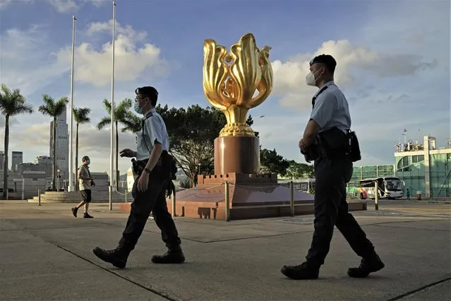 Police officers patrol at the Golden Bauhinia Square where the flag raising ceremony for the celebration of China's National Day will take place in Hong Kong, Saturday, June 25, 2022. (Photo by Kin Cheung/AP Photo)