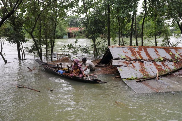 People get on a boat as they look for shelter during a widespread flood in the northeastern part of the country, in Sylhet, Bangladesh, June 19, 2022. (Photo by Kazi Salahuddin Razu/Reuters)