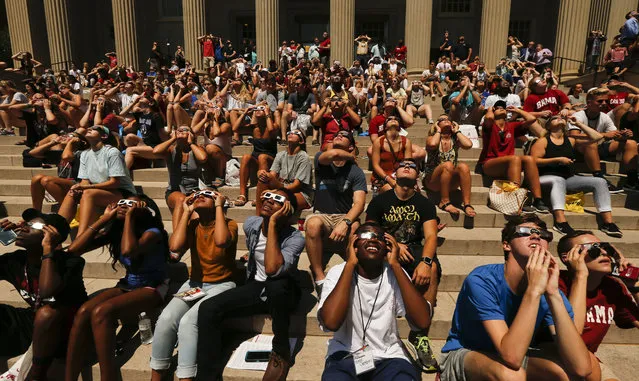 Students sitting on the steps of the Amelia Gayle Gorgas Library view the eclipse at the University of Alabama in Tuscaloosa, Ala., Monday, August 21, 2017. Viewers in Tuscaloosa saw approximately a 90 percent eclipse at 1:30 p.m. under mostly clear skies. (Photo by Gary Cosby Jr./The Tuscaloosa News via AP Photo)