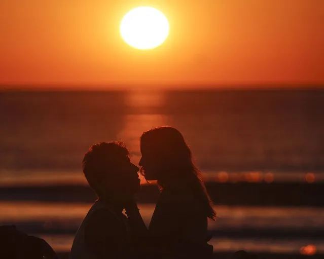 A couple kiss at sunrise the morning after the Saint John's Eve celebrations at Malvarrosa beach in Valencia, Spain, 24 June 2022. Saint J​ohn's Eve marks the shortest night of the year. (Photo by Manuel Bruque/EPA/EFE)