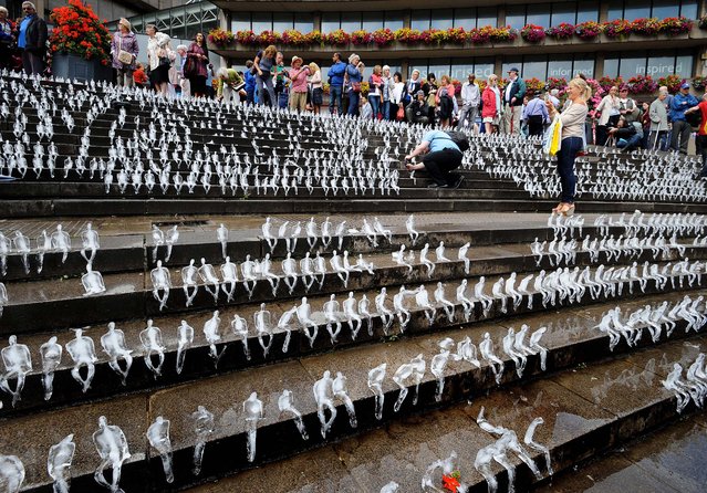 Some of the 5,000 figures made out of ice form the Minimum Monument, a major exhibition by Brazilian artist Nele Azevedo, part of Birmingham City Council's World War One Commemorations, on the steps of the city's Chamberlain Square, in Birmingham, England, on August 2, 2014. (Photo by Rui Vieira/PA Wire)