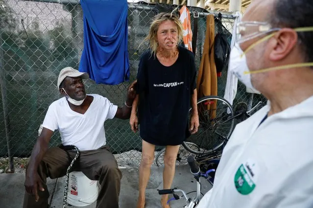 A homeless woman reacts next to a worker collecting samples during a Miami-Dade County testing operation for the coronavirus disease (COVID-19), in downtown Miami, Florida, U.S., April 16, 2020. (Photo by Marco Bello/Reuters)