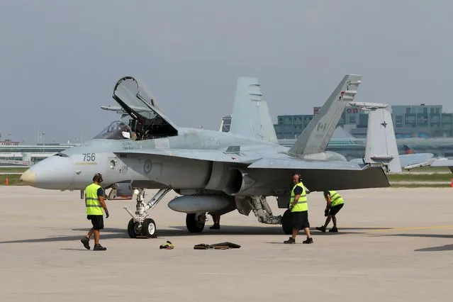 A CF-188 Hornet from 3 Wing Bagotville, Quebec is secured on the tarmac during media day for the Canadian International Air Show at Pearson Airport in Toronto, Ontario, September 3, 2015. (Photo by Louis Nastro/Reuters)