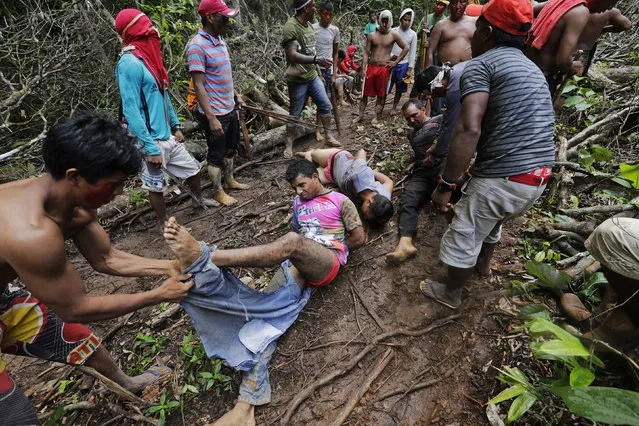 Ka'apor Indian warriors tie up and remove the pants of loggers during a jungle expedition to search for and expel them from the Alto Turiacu Indian territory, near the Centro do Guilherme municipality in the northeast of Maranhao state in the Amazon basin, August 7, 2014. (Photo by Lunae Parracho/Reuters)