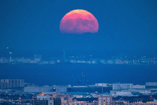 The full moon is seen from the observation deck of Roppongi Hills Mori Tower, during a harvest-moon viewing event in Tokyo on September 10, 2022. (Photo by Philip Fong/AFP Photo)