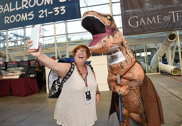 Inger Utke, left, takes a selfie with Edwin Galarza, dressed as a “Star Wars” themed dinosaur, during Preview Night at Comic-Con International held at the San Diego Convention Center, Wednesday, July 20, 2016, in San Diego. (Photo by Denis Poroy/Invision/AP Photo)