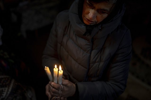 A woman prays inside the church during Christmas celebration in Kryvorivnia village, Ukraine, Sunday, December 24, 2023. (Photo by Evgeniy Maloletka/AP Photo)