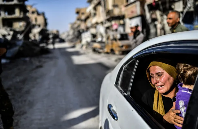 A woman cries as she looks at her house in Raqa on October 20, 2017, after a Kurdish-led force expelled the Islamic State group from the northern Syrian city. For three years, Raqa saw some of IS's worst abuses and grew into one of its main governance hubs, a centre for both its potent propaganda machine and its unprecedented experiment in jihadist statehood. (Photo by Bulent Kilic/AFP Photo)