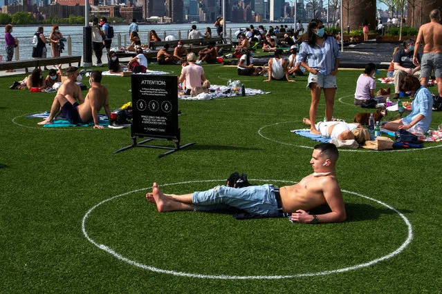 People try to keep social distance as they enjoy a warm afternoon during the outbreak of the coronavirus disease (COVID-19) at Domino Park in Brooklyn, New York, U.S., May 16, 2020. (Photo by Eduardo Munoz/Reuters)