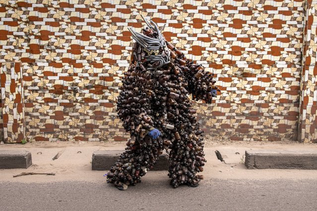 Musician and artist Jeje wears his costume made out of 1900 of his make shift plastic waste bottle trumpets in Kinshasa on December 24, 2023. The city of Kinshasa is littered with Musicians, dancers and bars with live music playing until the early hours of the morning. Congolese rumba is heard through out these bars, whether it’s the old traditional rumba or the new generations of Congolese musicians using it as a base to make new sounds, and creating new instruments using waste collected along the streets. (Photo by John Wessels/AFP Photo)