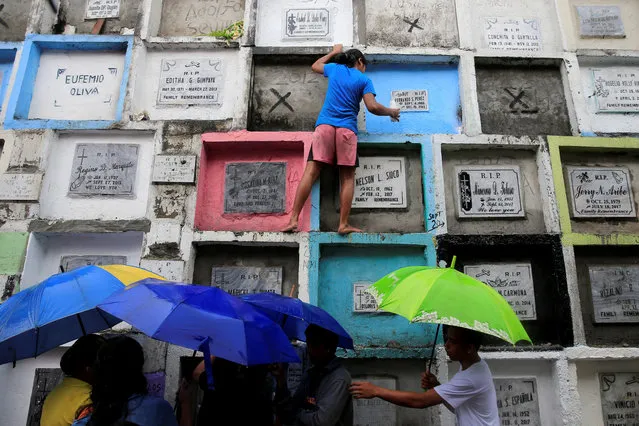 People visit apartment-style tombs of their loved ones during the observance of All Saints' Day at Navotas Public cemetery in Metro Manila, Philippines, November 1, 2017. (Photo by Romeo Ranoco/Reuters)