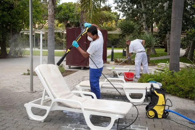 Employees disinfect the loungers at swimming pool area of the RIU Bravo Hotel in Palma de Mallorca on June 10, 2020 as the Balearic Islands prepare to welcome German tourists from June 15 as a test before Madrid reopens international borders on July 1. (Photo by Jaime Reina/AFP Photo)