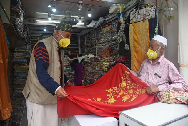 A costumer checks a shawl after shops reopened for business following the government's decision to ease the lockdown imposed as a preventive measure against the coronavirus, at Lal Chowk, on June 13, 2020 in Srinagar, India. (Photo by Waseem Andrabi/Hindustan Times/Rex Features/Shutterstock)