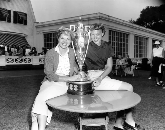 Barbara Romack of Sacramento, Calif., left, and Mickey Wright of La Jolla, Calif., right, pose with the championship cup after defeating their respective opponents to enter the final round of the Women's National Golf Championship, on September 17, 1954, in Pittsburgh, Pennsylvania. Miss Wright upset defending champion Mary Lena Faulk, and Miss Romack defeated Marjorie McMillen. (Photo by AP Photo)
