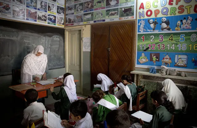 In this Saturday, October 5, 2013 file photo, Pakistani children attend class in a school in Mingora, Swat Valley, Pakistan. (Photo by Anja Niedringhaus/AP Photo)