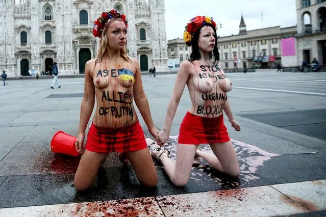 Inna Shevchenko (L), leader of the women's rights organization FEMEN, along with another activist, protest against Russia's President Vladimir Putin on the first day of the 10th Asia-Europe Meeting (ASEM) on October 16, 2014 at the Piazza del Duomo in Milan. Vladimir Putin will take centre stage at an Asia-Europe (ASEM) summit that opens today in Milan, where the Russian leader due to hold face-to-face talks with Ukraine counterpart Petro Poroshenko. (Photo by Marco Bertorello/AFP Photo)