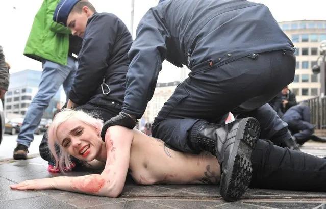 An activist of Ukraine's feminist movement Femen is taken away by the police as she demonstrates by the EU Council building where the EU-Russia summit is taking on December 21, 2012 in Brussels