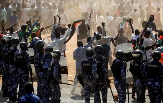 Riot police officers hold position against protesters near the Parliament buildings, as members of Sudanese pro-democracy protest on the anniversary of a major anti-military protest, while groups loyal to toppled leader Omar al-Bashir plan rival demonstrations, in Omdurman, Khartoum, Sudan on June 30, 2020. (Photo by Mohamed Nureldin Abdallah/Reuters)