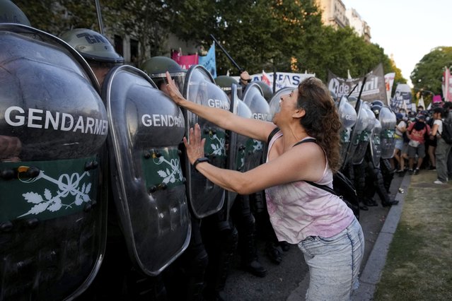 An anti-government protester charges at police deployed outside Congress where lawmakers are debating a bill promoted by Argentine President Javier Milei, in Buenos Aires, Argentina, Thursday, February 1, 2024. The bill includes a broad range of economic, administrative, criminal and environmental reforms. (Photo by Natacha Pisarenko/AP Photo)