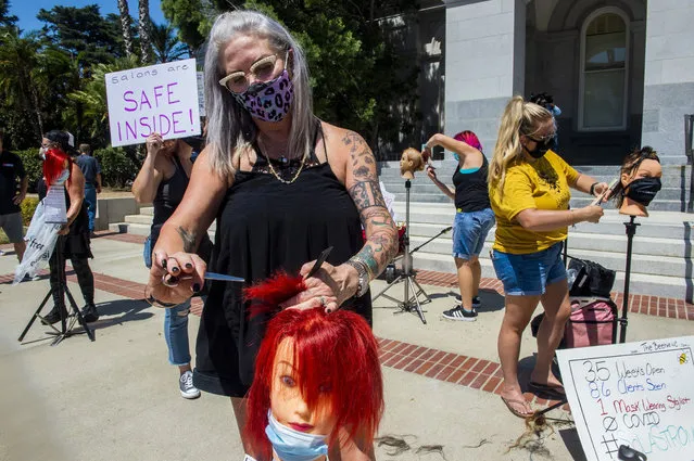 Kimberly Morris, of Walnut Creek, cuts the hair of a mannequin with other hairdressers at the California Capitol in downtown Sacramento, Calif., on Tuesday, August 11, 2020, as part of a protest against state coronavirus restrictions prohibiting salons from operating indoors. (Photo by Daniel Kim/The Sacramento Bee via AP Photo)