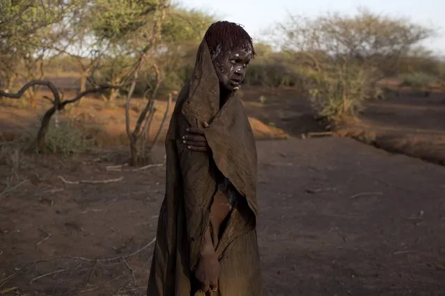 A Pokot girl, covered in animal skins, walks to a place where she will rest after being circumcised in a tribal ritual in a village about 80 kilometres from the town of Marigat in Baringo County, October 16, 2014. (Photo by Siegfried Modola/Reuters)