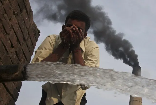 A labourer drinks water as smoke rises from a chimney of a brick factory at Togga village on the outskirts of the northern Indian city of Chandigarh in this December 6, 2009 file photo. India has promised to make its economy more energy efficient and to cut emissions intensity of its GDP by 33-35 percent by 2030 from 2005 levels, in a climate-change policy statement released ahead of a U.N. summit in Paris in December. (Photo by Ajay Verma/Reuters)