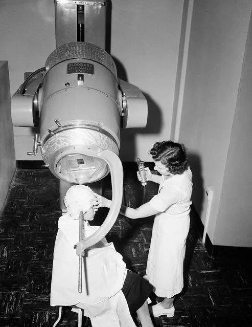 Radiation technicians Nancy Brown, right, and Isabelle Nauer illustrate the use of the Cobalt “bomb” machine at Montefiore, Hospital in New York on Feb. 7, 1953, as the new therapy unit makes its bow. Miss Nauer wears a plaster cast of the type moulded on a patient's head in a brain tumor case. After conventional x-rays locate the tumor, the cast is marked so that the Cobalt unit can be directed at the same point during each treatment. The “bomb” came from Canada's Chalk River Atomic Energy pile and produces more radiation than all the world's medically used radium. (Photo by AP Photo/JR)