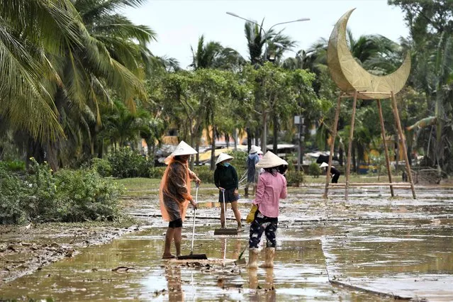 Residents clean a street following the passage of Typhoon Noru in Hoi An city, Quang Nam province on September 29, 2022. (Photo by Nhac Nguyen/AFP Photo)