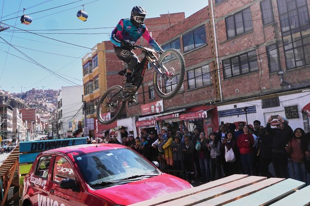 A competitor rides over a car during the Challenge Downhill mountain bike race in La Paz, Bolivia, Sunday, July 6, 2025. (Photo by Juan Karita/AP Photo)