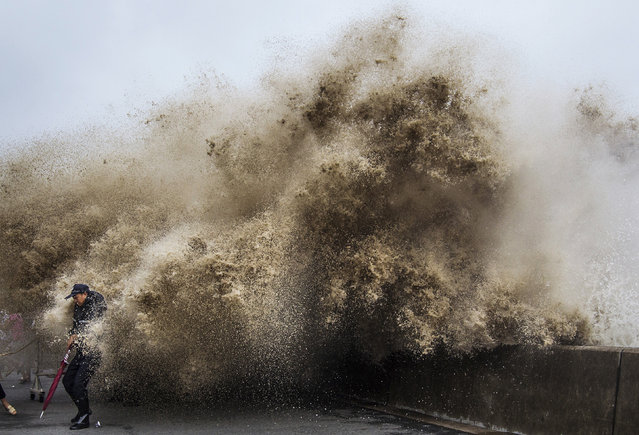 A man dodges tidal waves under the influence of Typhoon Usagi in Hangzhou, China, September 2013. (Photo by Chance Chan/Reuters)