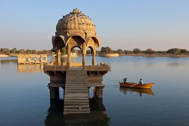 In this photograph taken on January 24, 2023, visitors view a building in Gadisar Lake in Jaisalmer in India's desert state of Rajasthan. (Photo by Sebastien Berger/AFP Photo)