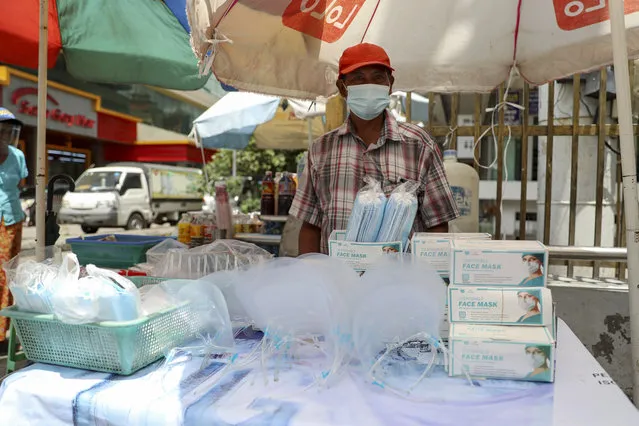 A vendor selling face masks and shields waits for customers at a roadside shop in Yangon, Myanmar, Thursday, September 10, 2020. Myanmar is accelerating efforts to control the spread of the coronavirus, which now has impinged on the upcoming November 8 general election, as campaigning has been ordered suspended in several areas locked down to control the spread of the virus. (Photo by Thein Zaw/AP Photo)