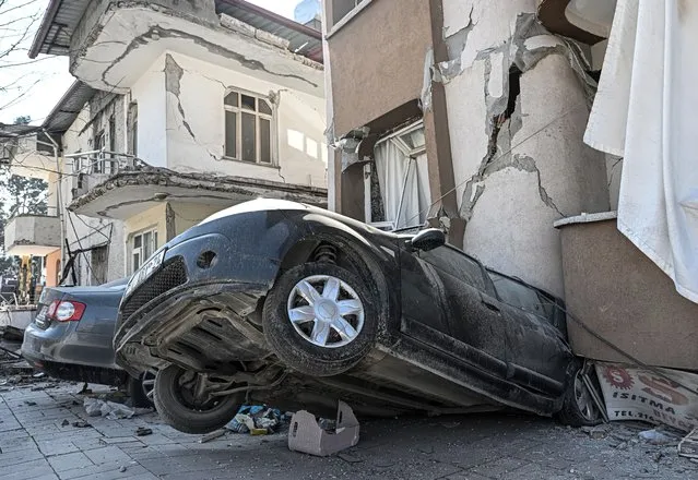 A view of a collapsed building on a car at the historical Antakya district in Hatay, Turkiye on February 22, 2023. On Feb. 06, a strong 7.7 earthquake, centered in the Pazarcik district, jolted Kahramanmaras and strongly shook several provinces, including Gaziantep, Sanliurfa, Diyarbakir, Adana, Adiyaman, Malatya, Osmaniye, Hatay, Kilis, and Elazig. Later, at 1.24 p.m. (1024GMT), a 7.6 magnitude quake centered in Kahramanmaras' Elbistan district struck the region. Two earthquakes jolted Turkiye's southernmost Hatay province on Monday, just two weeks after major quakes hit the region. According to the Disaster and Emergency Management Presidency (AFAD), one of the quakes took place at around 20.04 p.m. local time (1704GMT) in the Defne district of Hatay, with a magnitude of 6.4, while the other took place three minutes later, with the epicenter in Hatay's Samandag province, with a magnitude of 5.8. (Photo by Elif Ozturk Ozgoncu/Anadolu Agency via Getty Images)