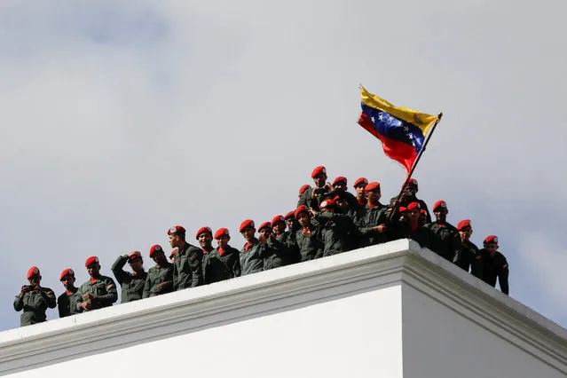 Members of Venezuela's presidential Honor Guard gesture from a rooftop as Venezuela's President Nicolas Maduro attends a rally to commemorate the anniversary of the ending of Marcos Perez Jimenez's dictatorship, who was ousted after a popular uprising in 1958, in Caracas, Venezuela on January 23, 2023. (Photo by Leonardo Fernandez Viloria/Reuters)