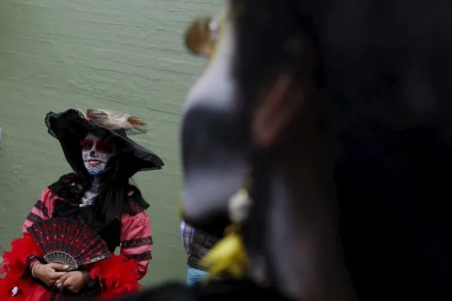 A woman with her face painted to look like the popular Mexican figure called "Catrina", looks on as she takes part in the annual Catrina Fest in Mexico City November 1, 2015. (Photo by Carlos Jasso/Reuters)