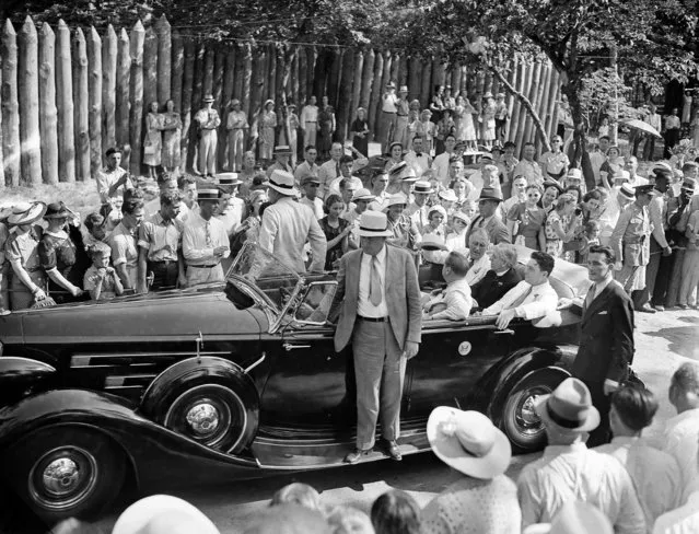 With stockades of the reconstructed old Fort Raleigh in the background, President Franklin D. Roosevelt arrives for his address on the “lost colony”, August 18, 1937. Next to him in the back seat of the auto is Gov. Clyde R. Hoey of North Carolina and next to him, closest to camera, is Rep. Lindsay C. Warren (D-N.C.). (Photo by eorge R. Skadding/AP Photo)