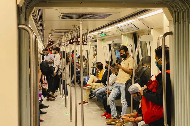 Commuters wear face masks as a precautionary measure against the coronavirus and travel in a metro train in New Delhi, India, Friday, November 6, 2020. (Photo by Rajesh Kumar Singh/AP Photo)