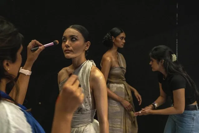 Makeup artists give final touches to models backstage before the start of a show during the Lakme Fashion Week X FDCI in Mumbai, India, Thursday, March. 9, 2023. (Photo by Rafiq Maqbool/AP Photo)