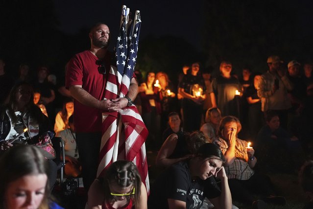 Ryan Shaw holds American flags during a vigil for Charlie Kirk on Friday, September 12, 2025, in Provo, Utah. (Photo by Lindsey Wasson/AP Photo)