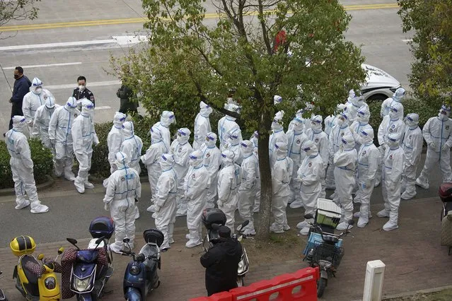 Security workers in protective suit prepare for administering COVID-19 testings for workers at the parking lot of the Shanghai Pudong International Airport in Shanghai, Monday, November 23, 2020. Chinese authorities are testing millions of people, imposing lockdowns and shutting down schools after multiple locally transmitted coronavirus cases were discovered in three cities across the country last week. (Photo by AP Photo/Stringer)