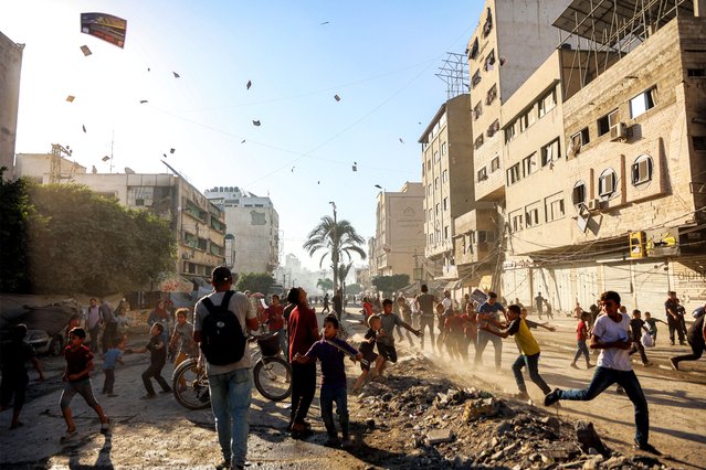 People watch as leaflets dropped by the Israeli military, urging evacuation south to al-Mawasi, land in Gaza City on September 9, 2025. The Israeli military said on Tuesday that it will act with “greater force” in Gaza City and warned residents to flee, in a statement posted on X. Israel has been intensifying its bombardment of the city in preparation for an operation to take control of it, despite repeated entreaties from Western nations and aid agencies to stop. (Photo by Omar Al-Qattaa/AFP Photo)